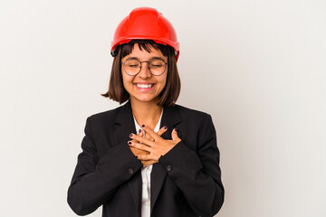 Wall Mural - Young architect woman with red helmet isolated on white background laughing keeping hands on heart, concept of happiness.