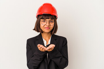 Wall Mural - Young architect woman with red helmet isolated on white background holding something with palms, offering to camera.