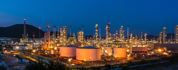 Aerial view. Oil refinery factory and oil storage tank at twilight and night. Petrochemical Industrial. Banner panorama.