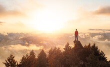 Adventurous Caucasian Adult Man Hiker Standing On Top Of A Rocky Mountain. Sunset Sky. 3d Rendering Peak. Aerial Background Image From British Columbia, Canada. Extreme Adventure Concept