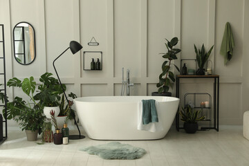 Wall Mural - Stylish bathroom interior with modern tub and beautiful houseplants. Home design