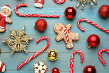 Wall Mural - Flat lay composition with tasty candy canes and Christmas decor on light blue wooden table