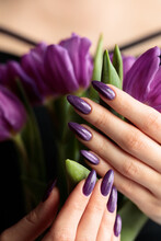 Girl With A Beautiful Violet Manicure Cat Eye Holding A Purple Tulips