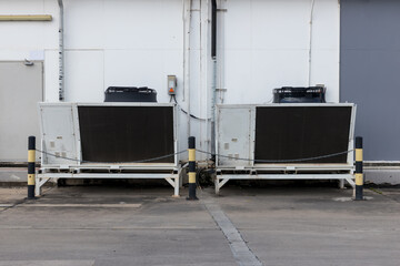 Air conditioner compressor installed in old building. Cooling towers in data center building. Industrial cooling towers or air cooled water chillers with piping system