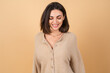 © Анастасия Каргаполов - Young woman on a beige background in a soft cozy sweater with daytime professional make-up cute smiling