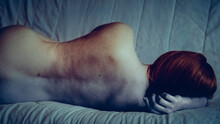 Rear View Of Woman Lying On Bed