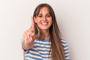 Wall Mural - Young caucasian woman isolated on white background showing number one with finger.