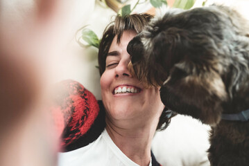 Wall Mural - Happy girl doing selfie with dog having fun and licking her face - Love and pet friendship