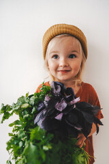 Wall Mural - Child with coriander and basil bunch vegan food healthy eating organic harvest gardening plant based diet nutrition sustainable lifestyle