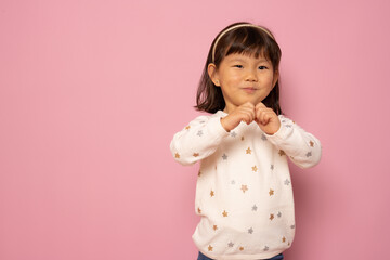 Wall Mural - Portrait of beautiful little asian girl isolated over pink background.