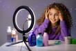 © КРИСТИНА Игумнова - beauty blogger girl leads a live broadcast, communicates with subscribers, answers questions, doing a review of cosmetics and care products. young woman vlogger. ring lamp. space for text