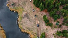 Birds Eye View Range Rover SUVs Driving Beside A Lake And A Forest