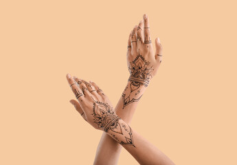Wall Mural - Female hands with henna tattoo on color background