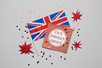 Greeting card with text GUY FAWKES NIGHT, flag of Great Britain and confetti on grey background