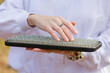 A woman holds a sadhu board in her hands and gently touches sharp nails with her fingers. Yoga on a sunny day outdoors. Alternative medicine, nail therapy, nailing, meditation.. Close-up.