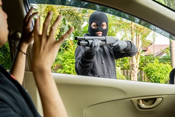 Wall Mural - Car thief man pointing a shotgun at the driver