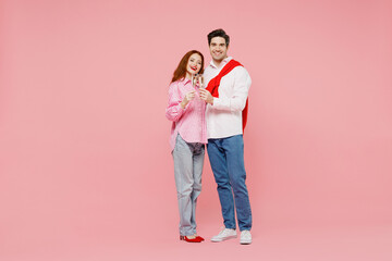 Wall Mural - Full body young couple two friends woman man 20s in shirt look camera hold wineglass with champagne raise toast isolated on plain pastel pink background Valentine's Day birthday holiday party concept