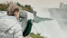 A Child Will Go Through A Large Stationary Binoculars To Niagara Falls. One Of The Most Famous Attractions Of The State Of New York And America