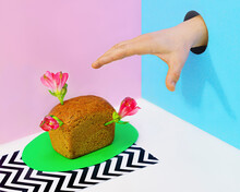 Hand In Hole Reaching For Mini Loaf Of Bread With Flowers

