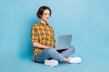 Poster - Photo of pretty focused lady sit floor remote work netbook wear checkered shirt isolated blue color background