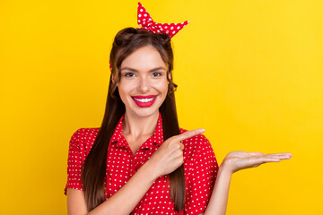 Poster - Photo portrait woman in red outfit showing finger blank space keeping on palm isolated vivid yellow color background