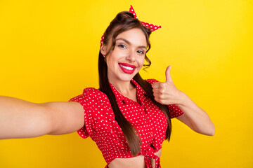 Poster - Photo of cute pretty young woman dressed red clothes smiling recording video showing thumb up isolated yellow color background