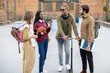 © rh2010 - Smiling multiracial students walk together at university campus. Concept of education and learning. Student lifestyle and friendship. Black man riding electric scooter. Idea of modern transportation