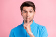 © deagreez - Photo of young serious brown haired male showing silence gesture shut up isolated on pink color background