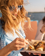 attractive girl eating sushi in sunglasses