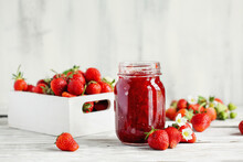 Homemade Strawberry Preserves Or Jam In A Mason Jar Surrounded By Fresh Organic Strawberries. Selective Focus With Blurred Foreground And Background.