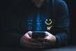 © Dilok - Businessman using smartphone for select smiley face icon for client evaluation and customer satisfaction after use product and service concept.