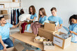 © Prostock-studio - Young multiracial volunteers sorting out donated clothes, talking with each other, working in charity donation center