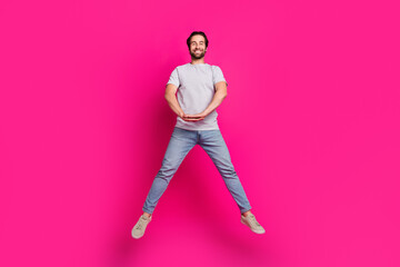 Canvas Print - Photo of funny handsome guy jump hold hands wear striped t-shirt jeans footwear isolated pink color background