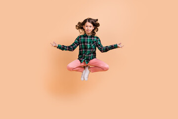 Wall Mural - Photo of peaceful dreamy schoolgirl wear plaid outfit jumping high practicing yoga smiling isolated beige color background