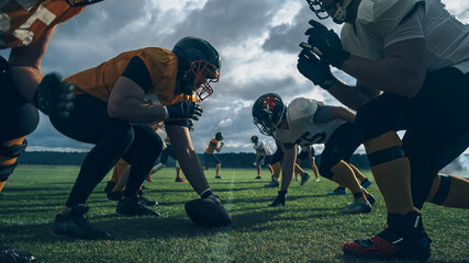 Two Professional American Football Teams Stand Opposite Each Other,  Ready to Start the Game. Defense and Offense Prepare to Fight for the Ball with Desire to Score Points and the Goal and Win.