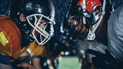 American Football Game Start Teams Ready: Close-up Portrait of Two Professional Players, Aggressive Face-off. Competition Full of Brutal Energy, Power, Skill. Rainy Night with Dramatic Light