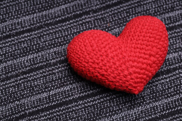 Sticker - beautiful heart lies on a gray knitted background. Love concept