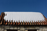 Fototapeta  - The sloping roof of the house, covered with a thick layer of snow. Symbol for Christmas holidays. House insulation