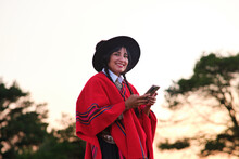 Happy Indigenous Ethnic Woman Using Smartphone In Countryside At Sunset