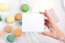 Present Card Holding Woman Hand In Vintage Gloves And Macaron Above White Textile