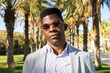 © ADDICTIVE STOCK - Serious black man adjusting stylish sunglasses in park