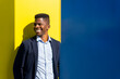© ADDICTIVE STOCK - Happy black man leaning on bright wall in sunlight