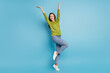 © deagreez - Photo of excited dream girlfriend lady enjoy party dance raise hands wear green shirt jeans isolated blue color background
