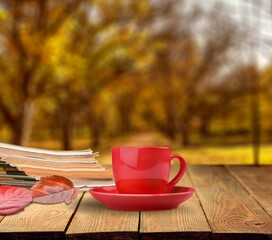 Sticker - Tea cup with bright fallen leaves and books in the garden. autumn seasonal composition.