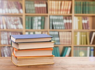 Poster - Stack of books on the table in the library background