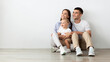 © Prostock-studio - Beautiful Young Family With Little Baby Looking Aside While Relaxing On Floor