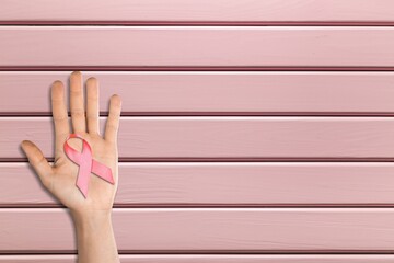 Sticker - Hand with pink ribbon on background. Breast cancer awareness concept