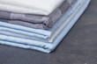 A stack of new fabric in white, gray, blue colors is neatly folded