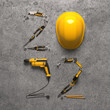 "2022" made from a set of construction tools and a protective helmet on a grey background. Creative 2022 New Year calendar or felicitation template for building and engineering companies. 3D render.