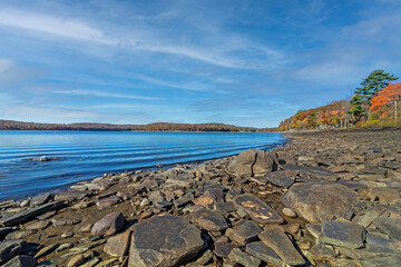 Lake Wallenpaupack in Poconos PA on a bright fall day lined with trees in vivid and beautiful foliage